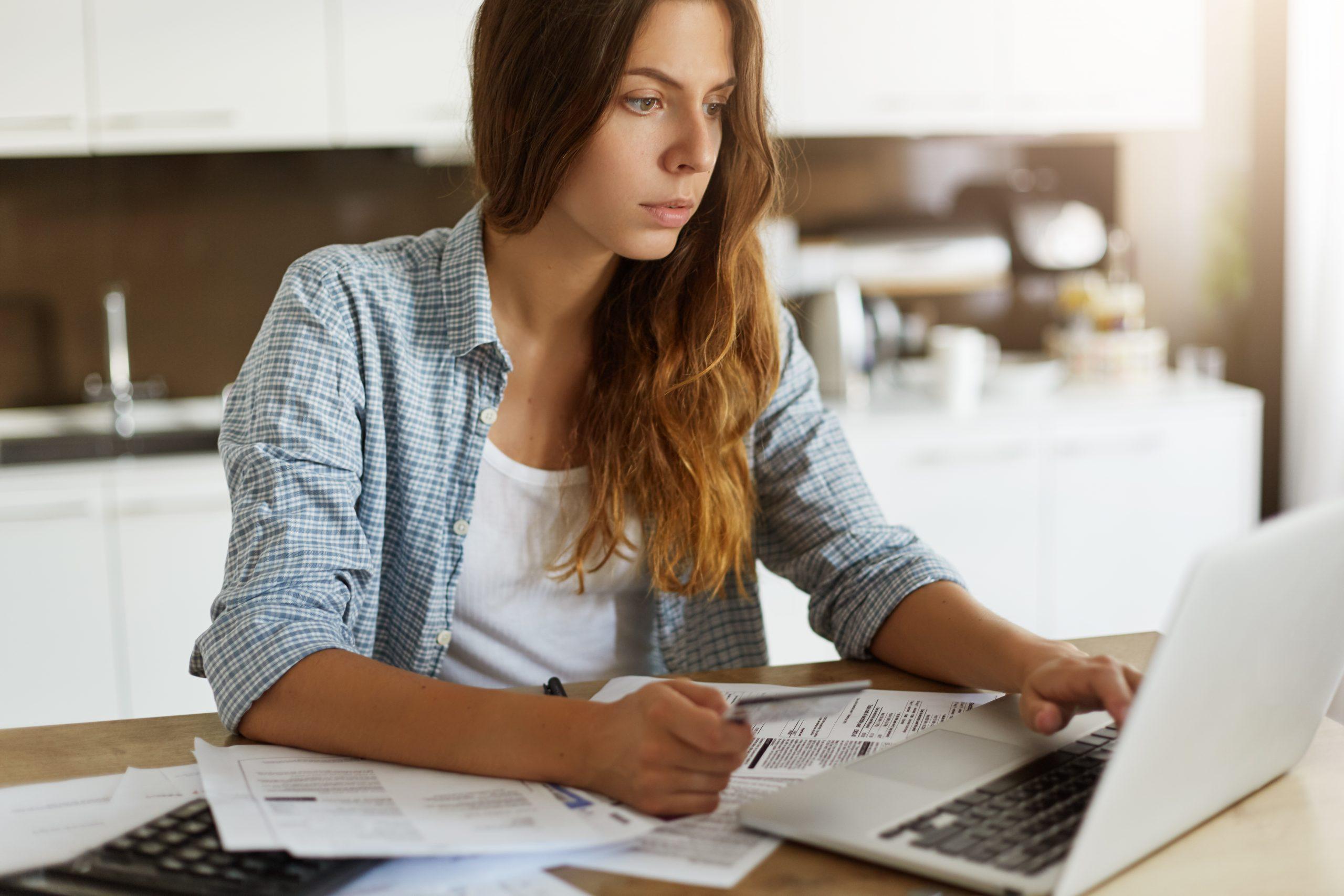 young woman checking her budget doing taxes 1 scaled